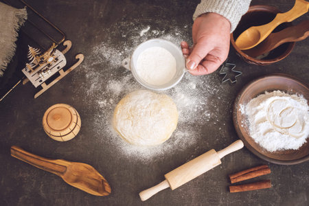 Process of making christmas cookies. Mature woman,  granny hands making dough.  Ingredients for...