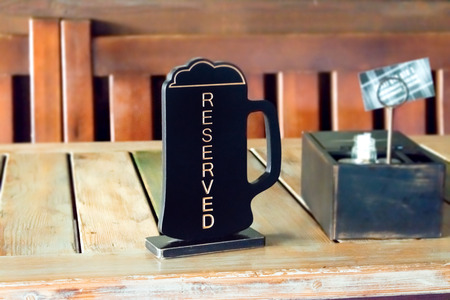 Beer pinta reserved sign on wooden table in pub, cafe, restaurant. Order lunch, dinner, breakfast in the pubの写真素材