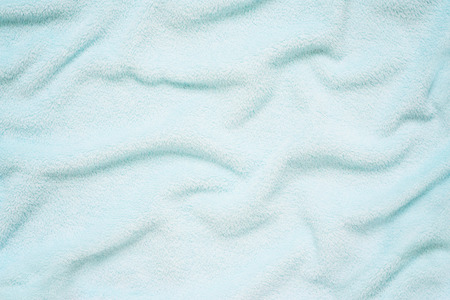 Fluffy Gentle baby blue fabric. Soft pastel textile texture. Folds on the soft fabric. Blue towel terry cloth.の写真素材