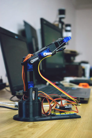 3D printed robot arm with wires and control board. Plastic manipulator, robotic hand machine tool...