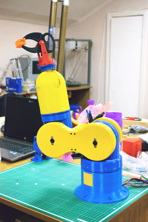 3D printed robot clamp, arm, holder. Plastic manipulator, robotic hand machine tool printed on three dimensional printer. DIY robotics, engineering, science, technology, computer codeの写真素材