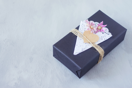 Valentines day craft gift box ideas. Black paper present box with heart, lace napkin, jute rope on grey cement background. Love, romance, handmade conceptの写真素材
