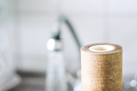 Dirty, brown, used water filter cartridges on background of the sink and tap with water, selective focusの写真素材