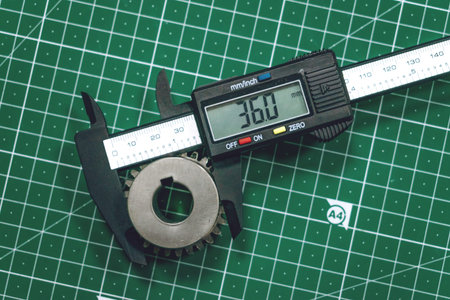 Metal gear measurement process. Measuring steel detail, gear with digital Vernier Caliper at...
