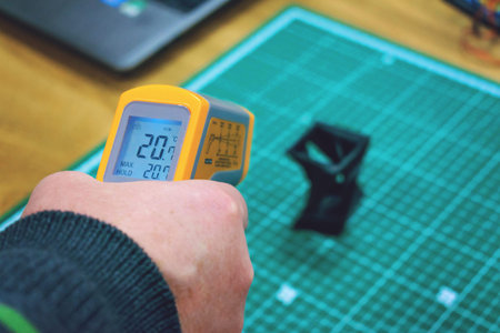 Kropivnitskiy, Ukraine â€“ 12 may, 2018: Laser thermometer. Yellow pyrometer in man hand....