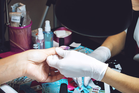 Kiev, Ukraine â 19 September, 2018: nail sticker, wraps procedure. How to Apply Nail Stickers. Beauty salon, manicure, woman and beautician for manicure.のeditorial素材