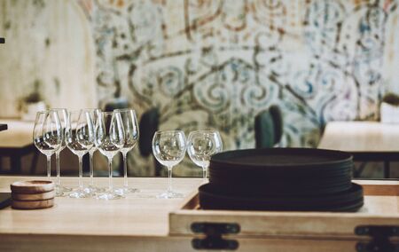 Natural clay brown plates, glass goblets and wooden saucers in a cafe. Porcelain dishware on wooden table. No plastic, zero waste cafe conceptの写真素材