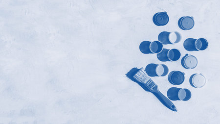 Blue Color background. Colorful glass beads pattern. Paints in round jars and brush on a gray concrete background with copy spaceの写真素材