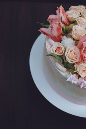 Delicate pink wedding cake with natural fresh beautiful flowers roses and lily. How To Put Fresh Flowers On A Buttercream Cake. Adding fresh flowers on cake.の写真素材