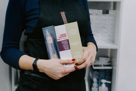 Permanent ammonia free hair colour, hair dye in hairdresser hand. Coloring in beauty salon. Color chart, palette, catalog in hairdressing salon. Kropivnitskiy, Ukraine, September 27, 2019.のeditorial素材