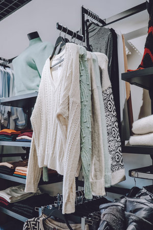 Sustainable living, Zero waste wardrobe. Secondhand fashion. Various clothes on hangers on shelves at local market, shop, store.の写真素材