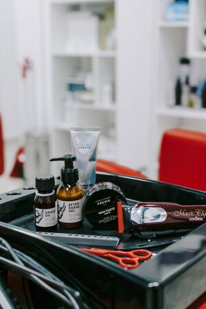 Male beauty. Man cosmetics and hairdresser tools in hairdressing salon. After shave gel, shave oil, paste matte, Cutting electric razor. Kropivnitskiy, Ukraine, September 27, 2019.のeditorial素材