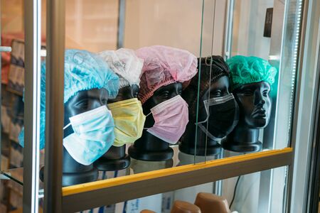 Disposable Mask with Earloops for Salon, Home Use. Different 3-Layer Disposable Face Surgical Mask on mannequins. Wearing mask won't protect from the coronavirus.の写真素材