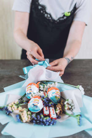 Sweet edible bouquet arrangement gifts from Kinder Surprise, chocolate egg with small toy for children. How to Make edible candy sweet Bouquet Steps, tutorial. Kropivnitskiy, Ukraine, January 7, 2020.のeditorial素材