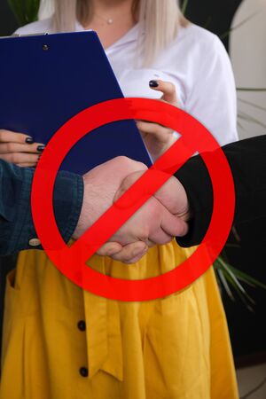 No Handshakes greeting to avoid the spread of coronavirus. Covid-19 Changes Etiquette. No handshake stop sign on businesses background. Keeping distance. Hygiene and Quarantine Conceptの写真素材