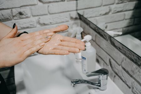 Gel hand sanitisers protect against the new coronavirus. Woman using bottle of antibacterial sanitiser soap gel. Soap, sanitizer and warm water work against Covid-19 and other virusesの写真素材