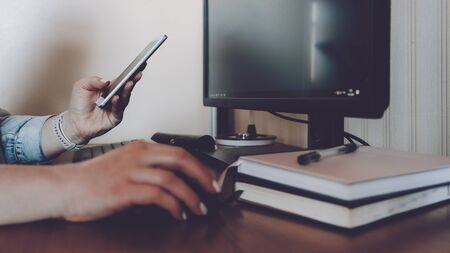 Coronavirus CYBER HYGIENE practices, Cyber distancing concept. Woman with smartphone in hands works at home PC computer.の写真素材