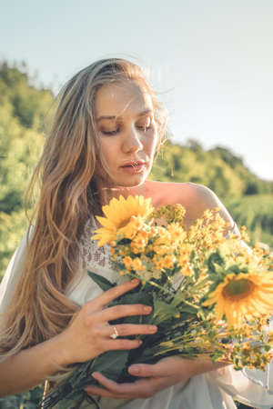How to Harvest and Dry Herbs. Traditional medicinal plants. Woman picking flower in summer field with sunlight ray.の写真素材