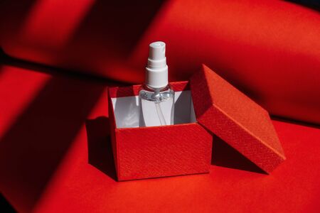 Deficit of hand sanitizer concept. Alcohol hand spray as gift in red gift box. Hand sanitizer gel for hand hygiene corona virus protectionの写真素材