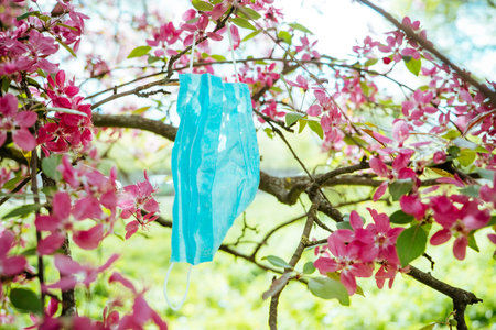 Quarantine Coronavirus pandemic end, post covid 19, new normal concept. Face Masks on blooming pink...