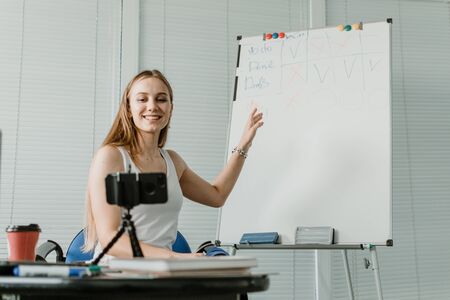 Online meetings, remote teamwork discussing, virtual meeting. Business woman talking to her colleagues in video conference. Multiethnic business team using laptop and smartphone for video callの写真素材