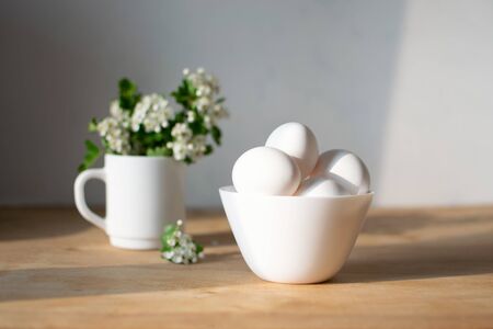 National egg day background with white eggs in bowl and flowers in green vase. National Egg Day on June 3の写真素材