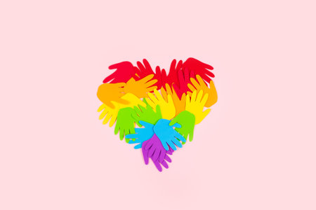 Pride, LGBT flag symbol concept with rainbow color palm hands heart butterfly shape on pink...