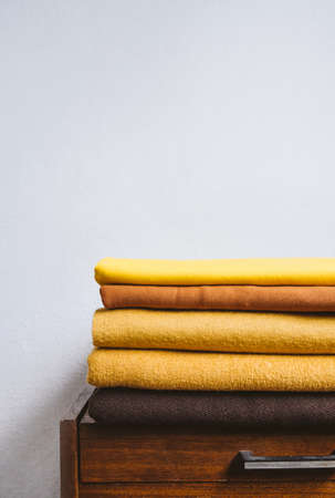 Fall autumn Minimalism, simple, Neutral color negative space background mockup with copy space. Fall autumn color palettes compositions with stack of yellow brown fabrics.の写真素材