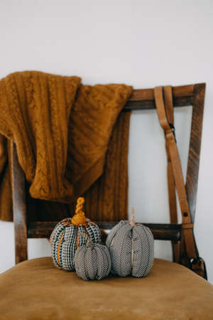 Small Fabric Decorative Pumpkin on mustard retro chair. Handmade, Autumn Fall Decor, Thanksgiving and Halloween Table Decor. DIY Crafts.の写真素材