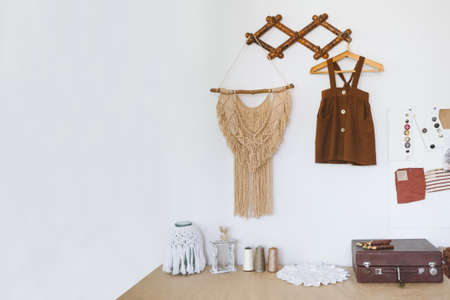 Cute Nursery Decorating Ideas, Baby Room Designs decor. Toddler baby Organic cotton clothes hanging on the rack and rustic retro accessories on white wallの写真素材