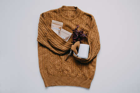 Autumn fall mood, Cocoa, Hot chocolate time. Ingredients for hot chocolate, cocoa powder, marshmallows and white cup on knitted sweater background.の写真素材