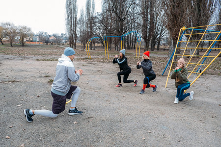 Group fitness classes outdoors. Organized gym classes set up in public parks. Three women and man...