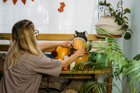 Young woman decorate house for Halloween. Interior of the house decorated for Halloween with DIY...