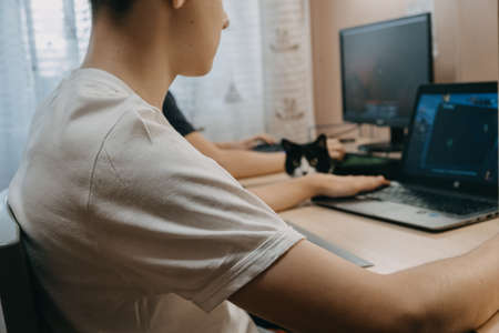 Esports, competition, gaming, multiplayer, live streaming. Two Boys playing online video game on playstation. Two teenager in front of the computer. Kropivnitskiy, Ukraine, September 20, 2020のeditorial素材