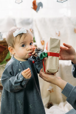 Boxing day, Saint Nicholas Day. Baby girl and mom unpacked boxes with gifts in Christmas-tree...