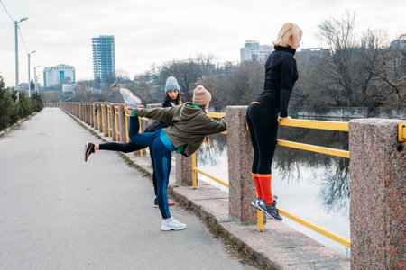 Group fitness workout classes outdoors. Organized gym classes set up in public parks. Three women...