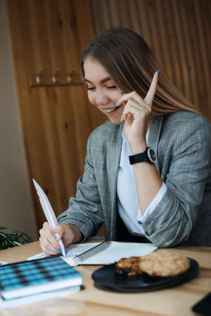 Foods to Boost Brain and Memory. Foods linked to better brainpower. Young girl, teen, student with open book in her hands and healthy grain cookies reading and studying in cafeの写真素材