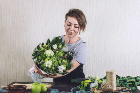 Floral Design Courses Online, Florist business, small business, Flower Arranging, florist trends. Florist woman shows master class, tutorial on creating organic flower fruit edible bouquetの写真素材