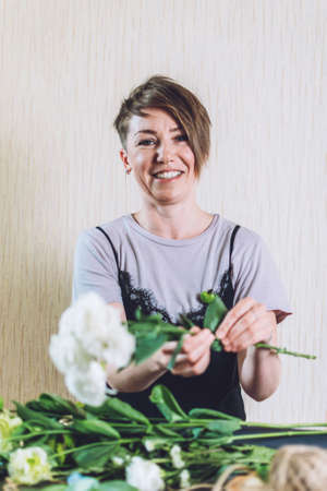 Floral Design Courses Online, Florist business, small business, Flower Arranging, florist trends. Florist woman shows master class, tutorial on creating organic flower fruit edible bouquetの写真素材