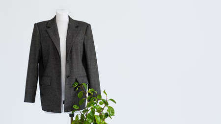 Sustainable fashion, organic clothes, eco clothing, ecology, sustainability, responsible fashion, 100 cotton. Formal Bio fabric suit with green plants on light background.の写真素材