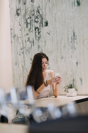 Slender slim brunette girl talking on the cell phone in cafe. Body health, slimness, self-loveの写真素材