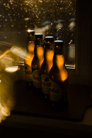 Hoegaarden beer many bottles with golden bokeh in sunlight. Beer mood, soft drink, cold alcohol beverage, refreshment.のeditorial素材
