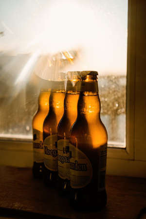 Hoegaarden beer many bottles with golden bokeh in sunlight. Beer mood, soft drink, cold alcohol beverage, refreshment.のeditorial素材