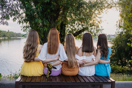 Group of happy young women, female friends having fun on summer nature background. Many young female friends together looking the sunset. Female Friendship and Forever friends conceptの写真素材