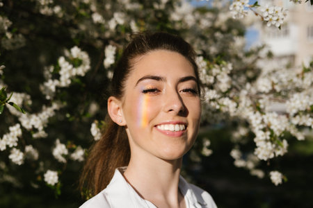 Spring time, Natural beauty. Candid portrait of young women in cherry blooming garden. Pretty woman...
