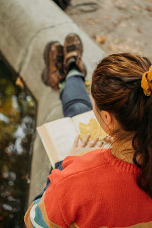 Young plus size woman reading book in fall autumn park in sun lights. Body positive, diversity, Body neutrality, body positivity, resolutions self-improvementの写真素材
