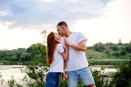Budget-Friendly Honeymoon Destinations, Romantic getaway, solo couple travel. Couple in love, newlyweds in white t-shirt having fun on nature background. Young couple enjoying in local travelの写真素材