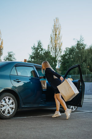 Shopping, sale, Happy young stylish blonde woman with shopping bags opening car after shopping. Girl...