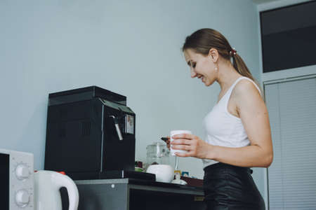 Employee care, caring in the workplace, Engagement and Retention. Young business woman drinking coffee in office break room during lunchtimeの写真素材