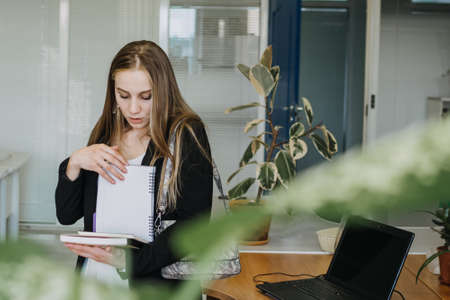 Multitasking Skills Employers, Work burnout, Tired At Work. Busy young blonde businesswoman with many papers and notebooks working at officeの写真素材